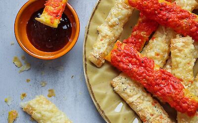 Making crispy cheese sticks from puff pastry with red pesto cheese